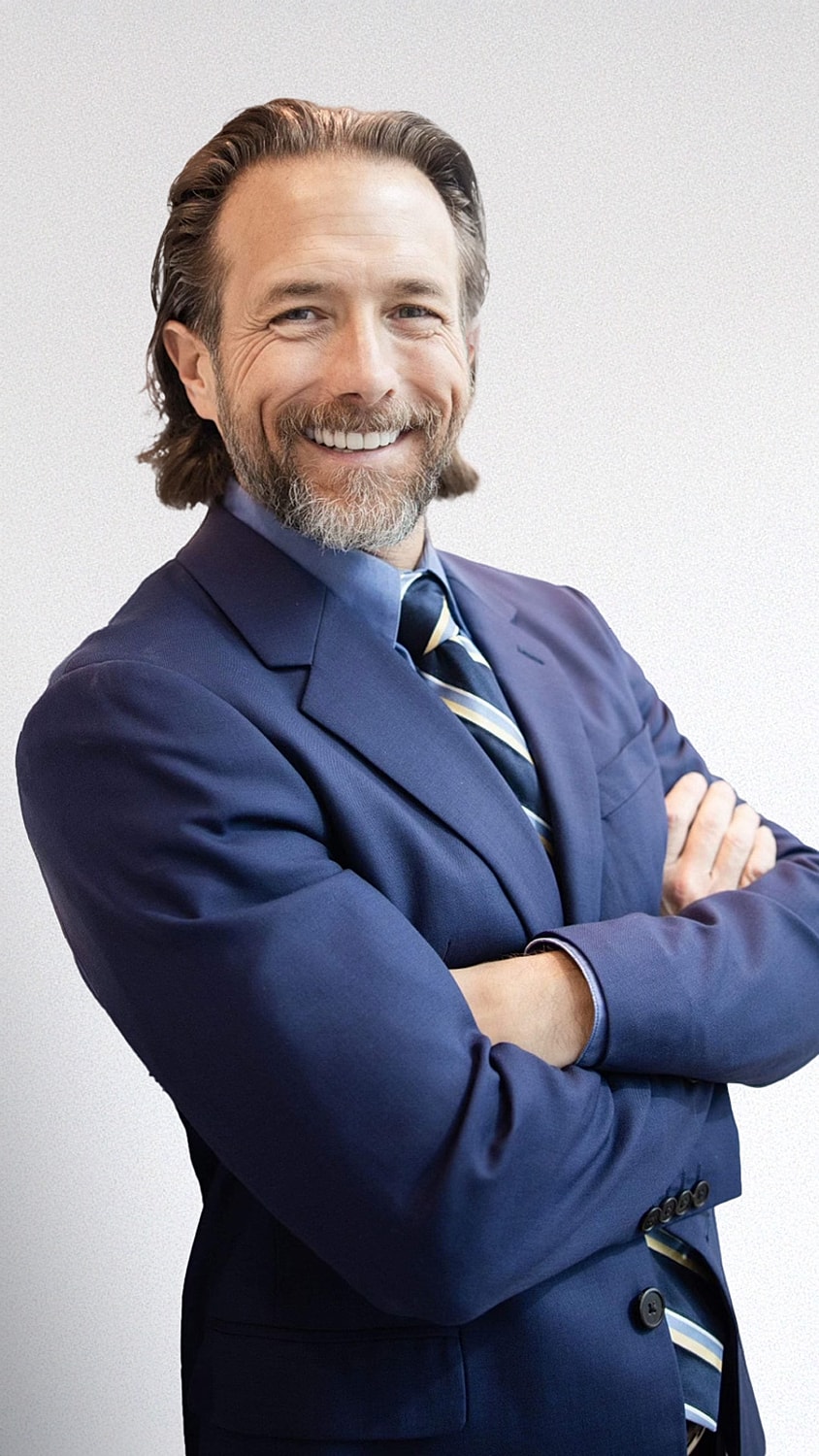 Smiling man in a formal suit and tie.