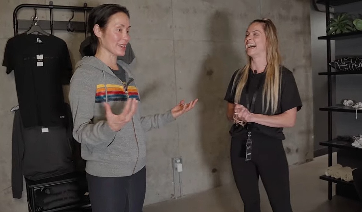 Two women talking in a modern clothing store.